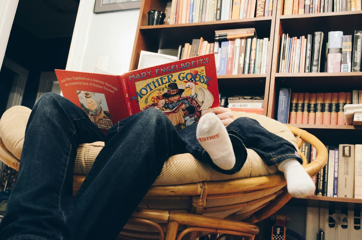 Child choosing a book from library shelves